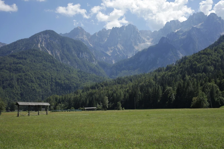 green mountain meadow with a shed near by