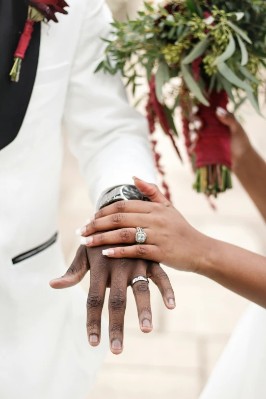 two people holding hands on the other side of the bride and groom