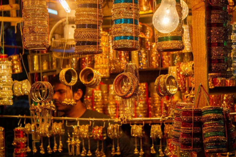 man looking through a shop window with celets and lamps