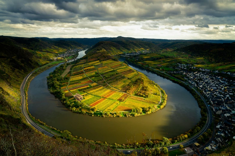 an aerial view of an unparaved river and green valley