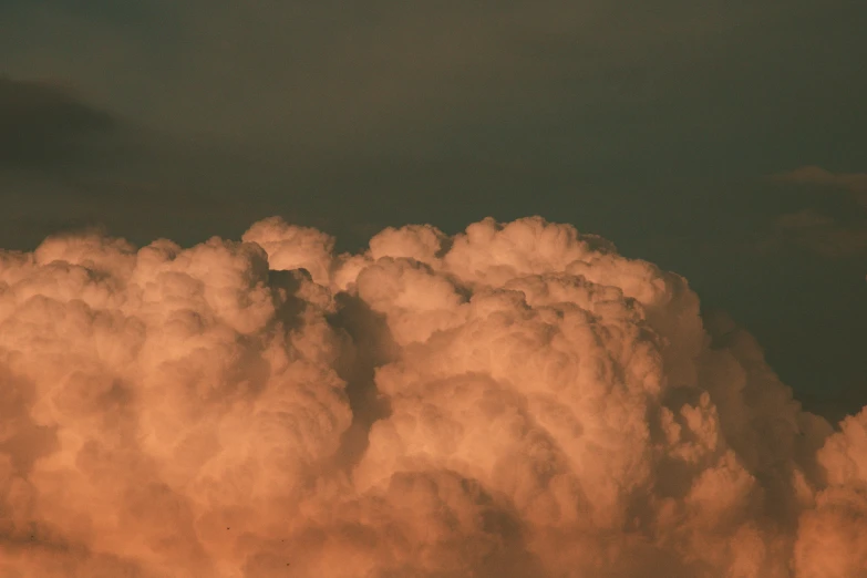 an airplane flying overhead a cloud filled sky