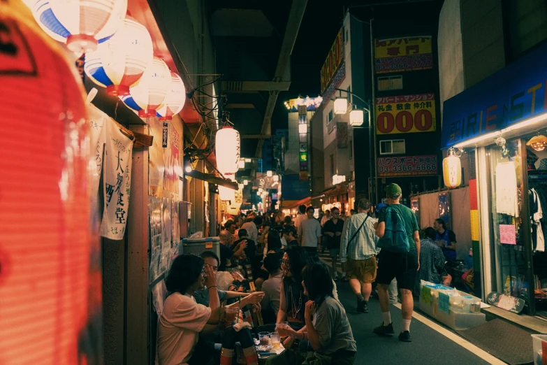 people are gathered inside of an alley as they eat