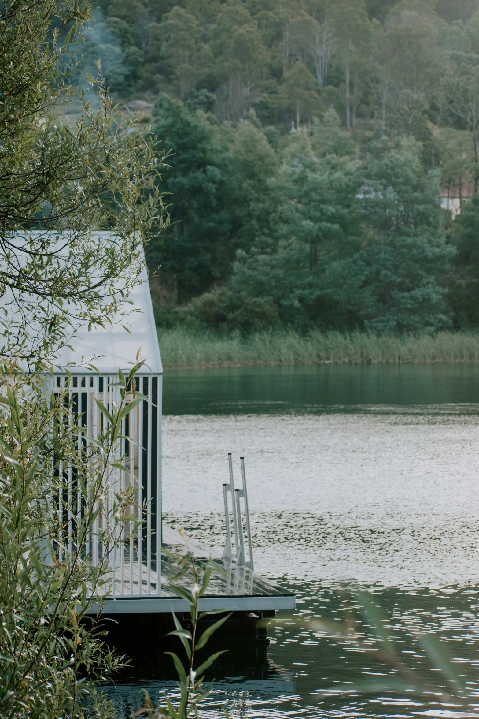 a small, white structure on the edge of water is placed in front of a dock