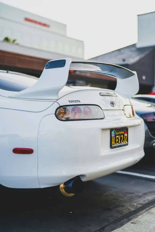 a white car parked in front of a car shop