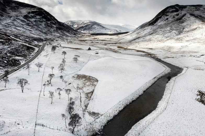 a stream in the middle of a snow covered valley