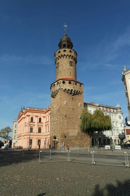 a tall brick tower with a cross at the top