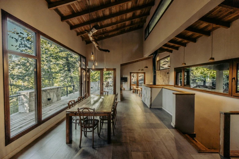 this is a dining room with glass walls and a wood ceiling