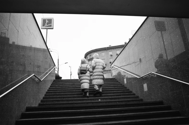 black and white pograph of person walking up stairs