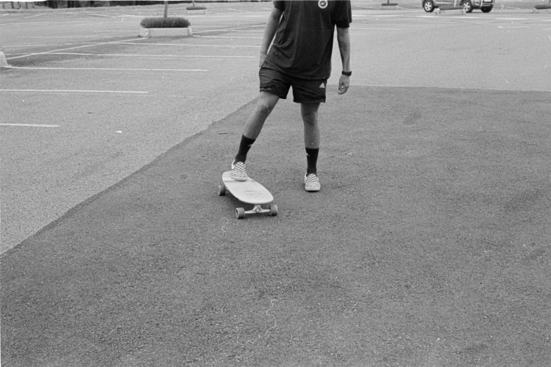 black and white po of a person standing on a skateboard