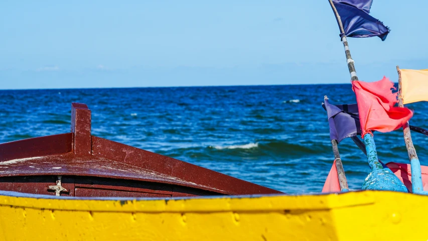 a small boat in the middle of water with flags