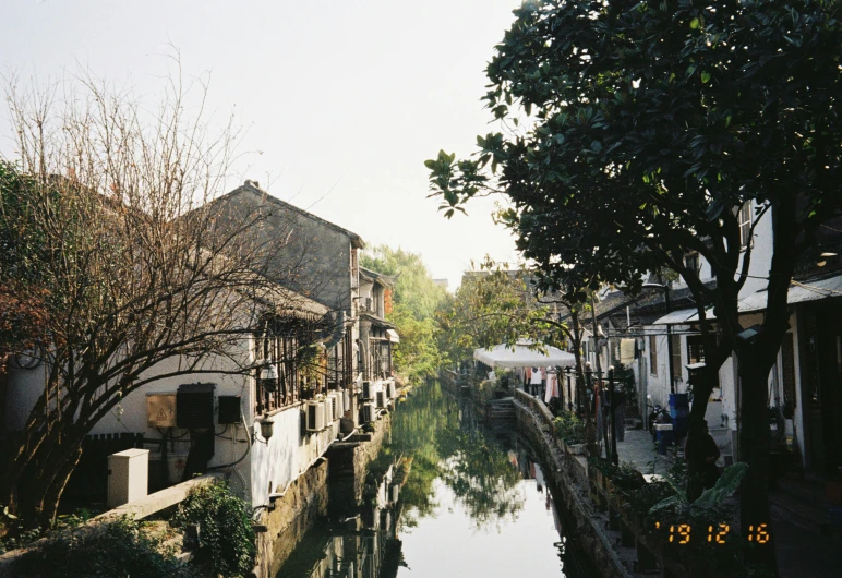 buildings are shown next to a river and trees