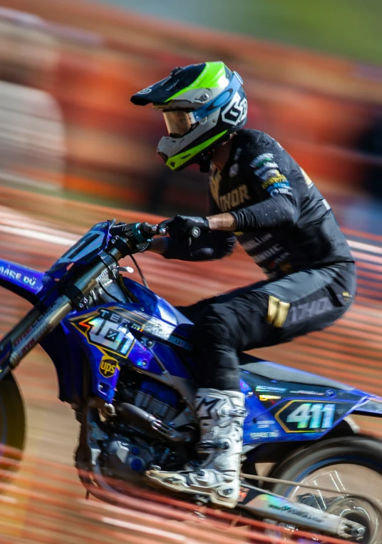 a man riding on the back of a blue dirt bike