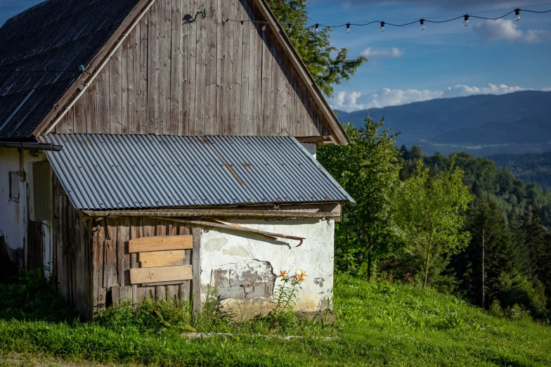 a barn on top of a mountain with a small house next to it