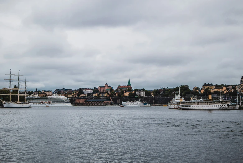 several ships on the water near some buildings