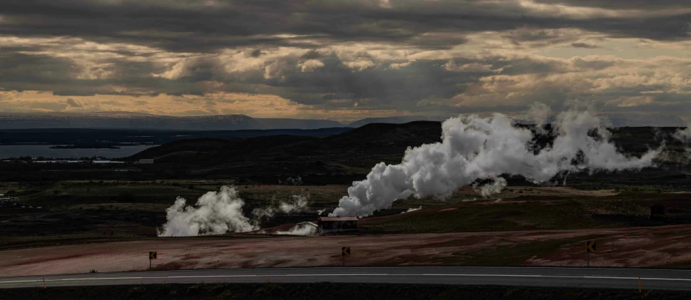 steam emits from the pipes coming out of a large pipe