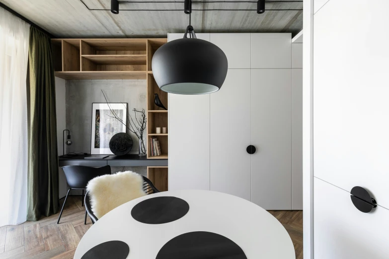 an empty room with black and white chairs and large round table