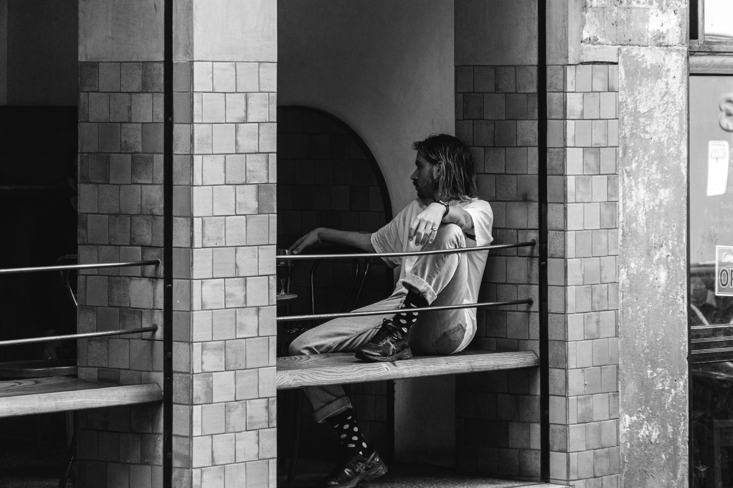 black and white pograph of a woman sitting on a window ledge