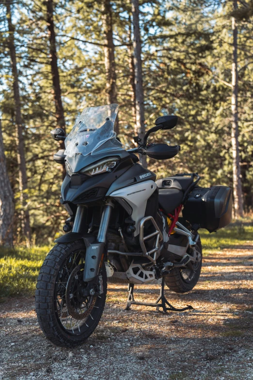 a motorcycle parked on top of a dirt road in a forest