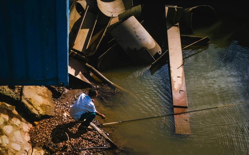 a person standing in some water with a blue container