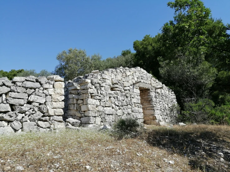 an old stone house is covered in small boulders