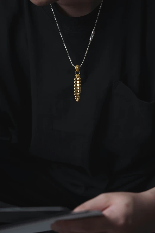 a person reading a book while wearing a long necklace