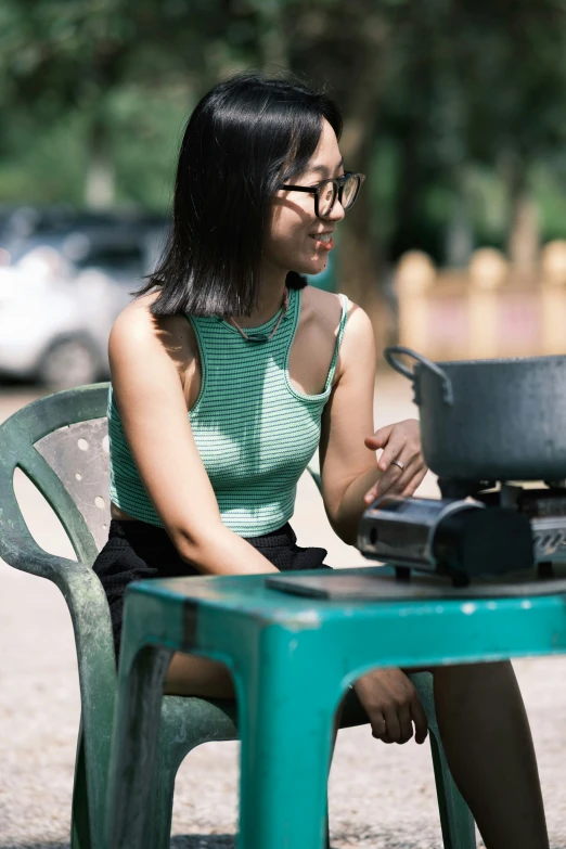 a girl wearing glasses sitting at a table with pots