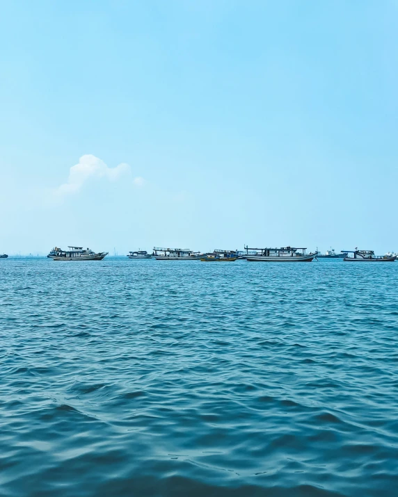 a large group of fishing boats floating in the ocean