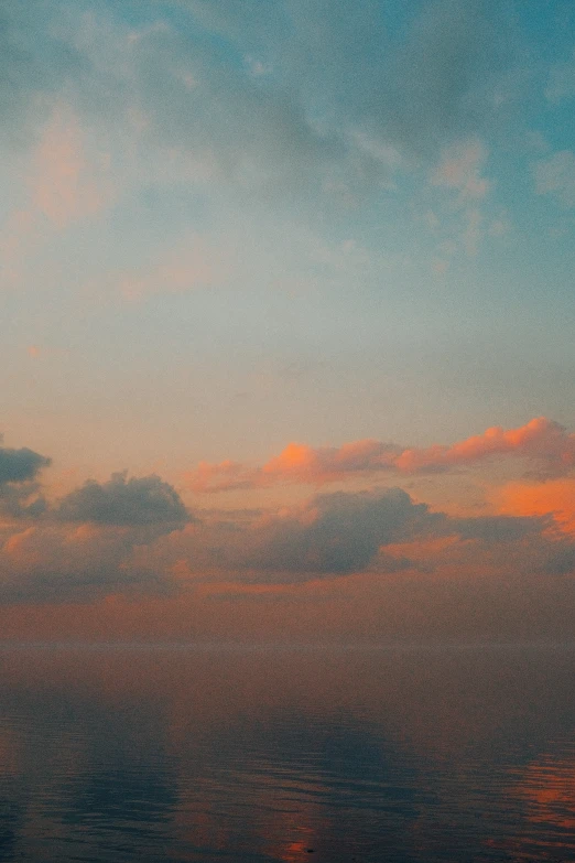 a very pretty sky with some clouds and a plane in the distance