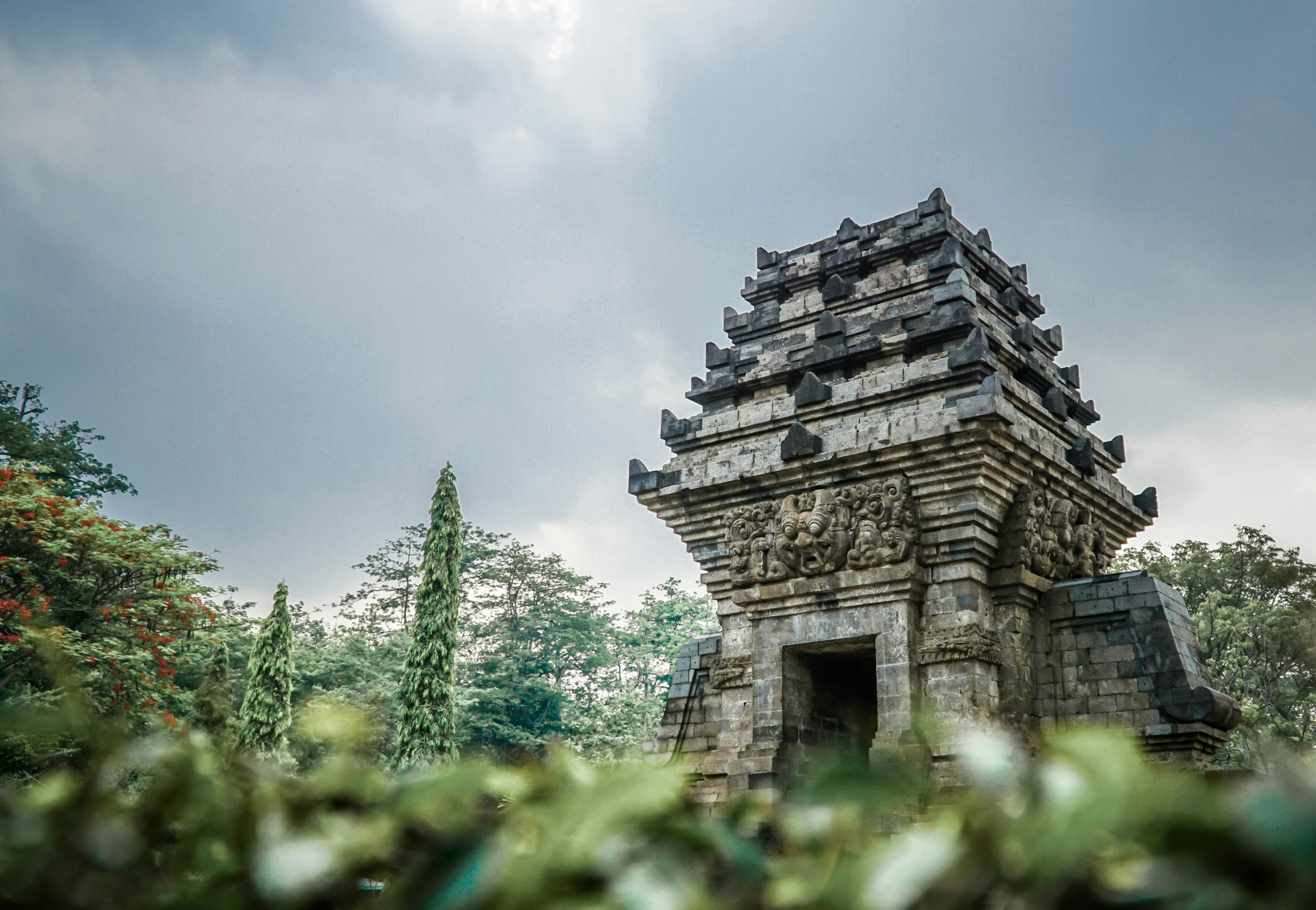 a stone clock tower with birds perched on it