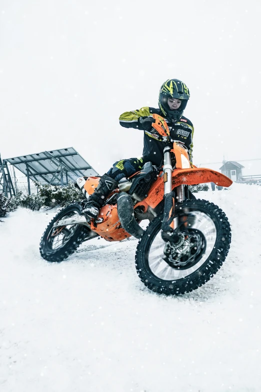 a person on a motorcycle driving through snow