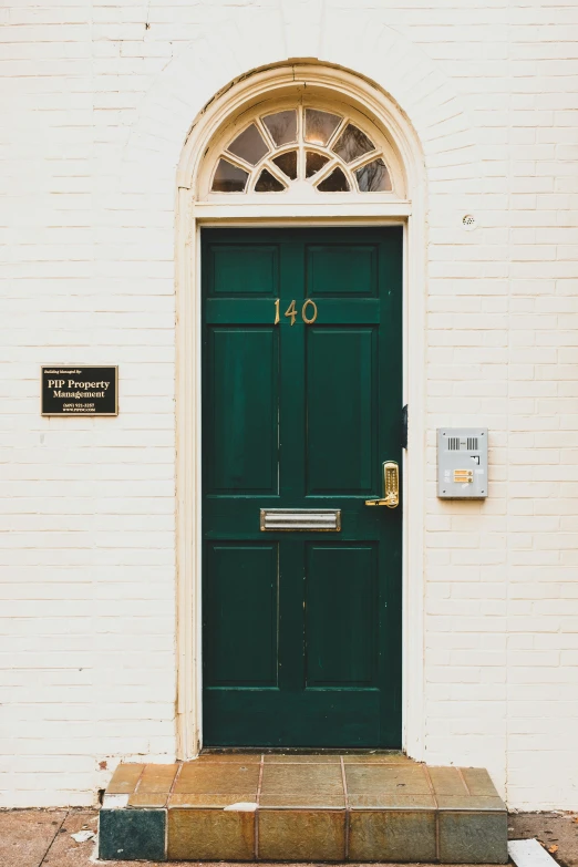 front door with brick wall and green doors