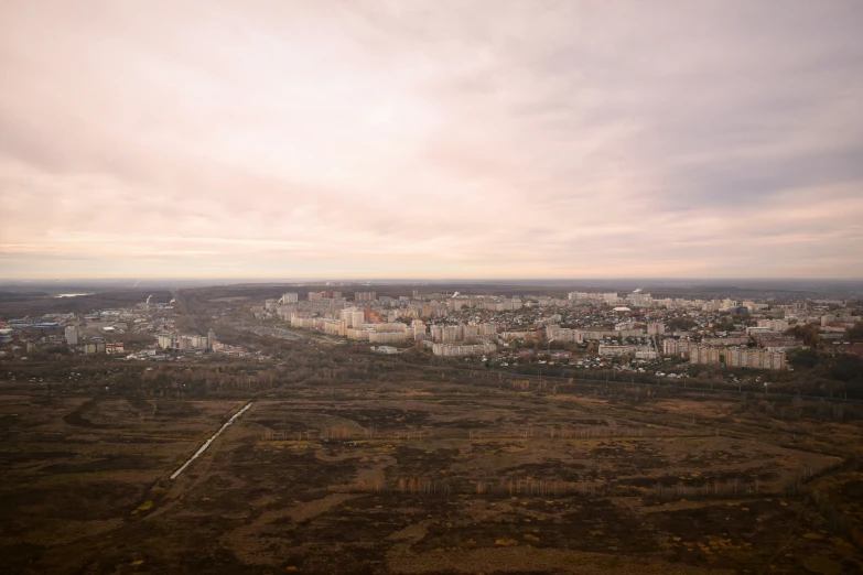 an aerial s of a city and field under cloudy skies