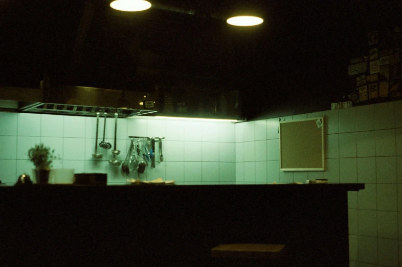 a dimly lit kitchen counter with a pot and pan on it