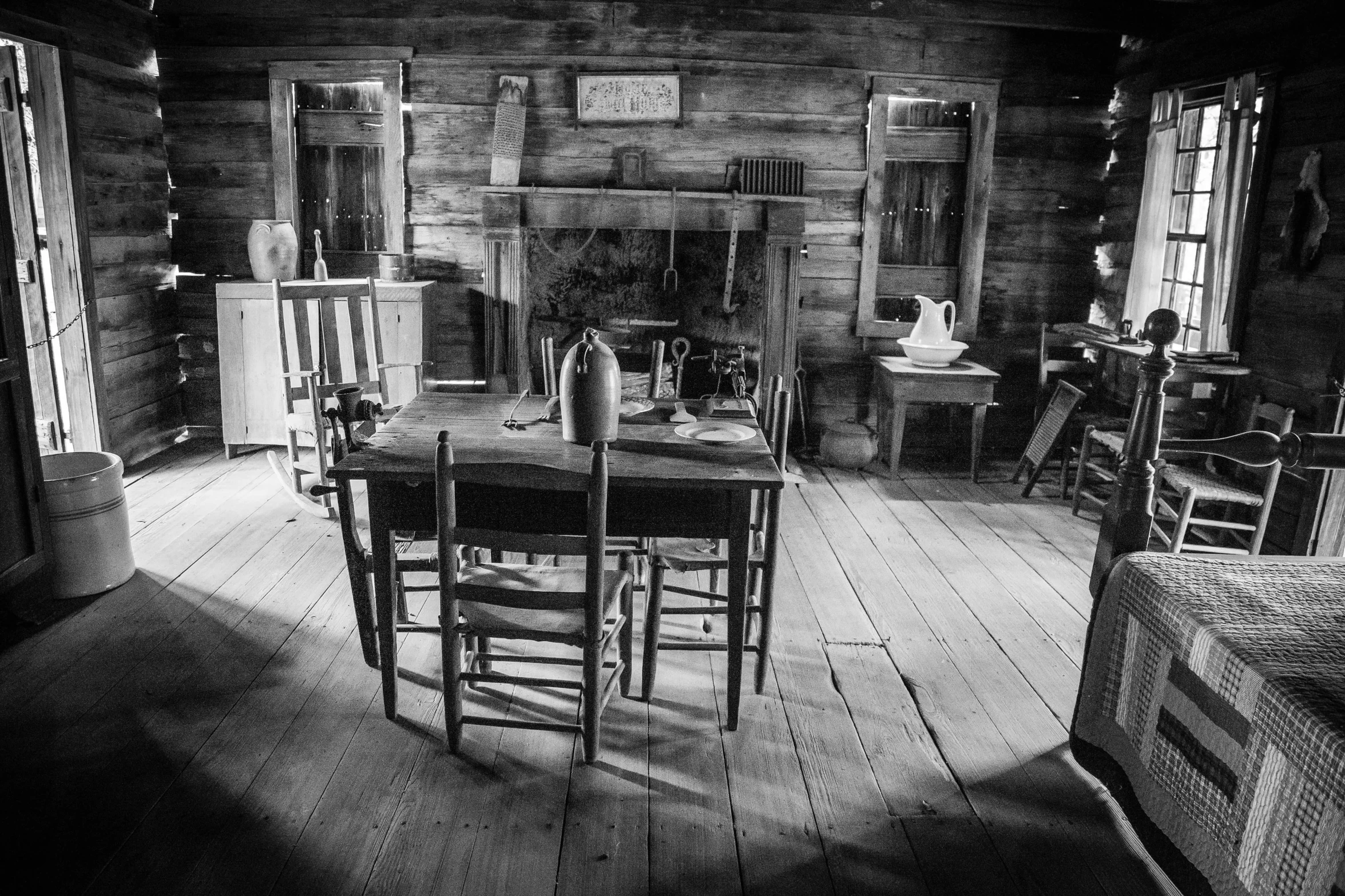 a chair and table in an old, rustic looking cabin