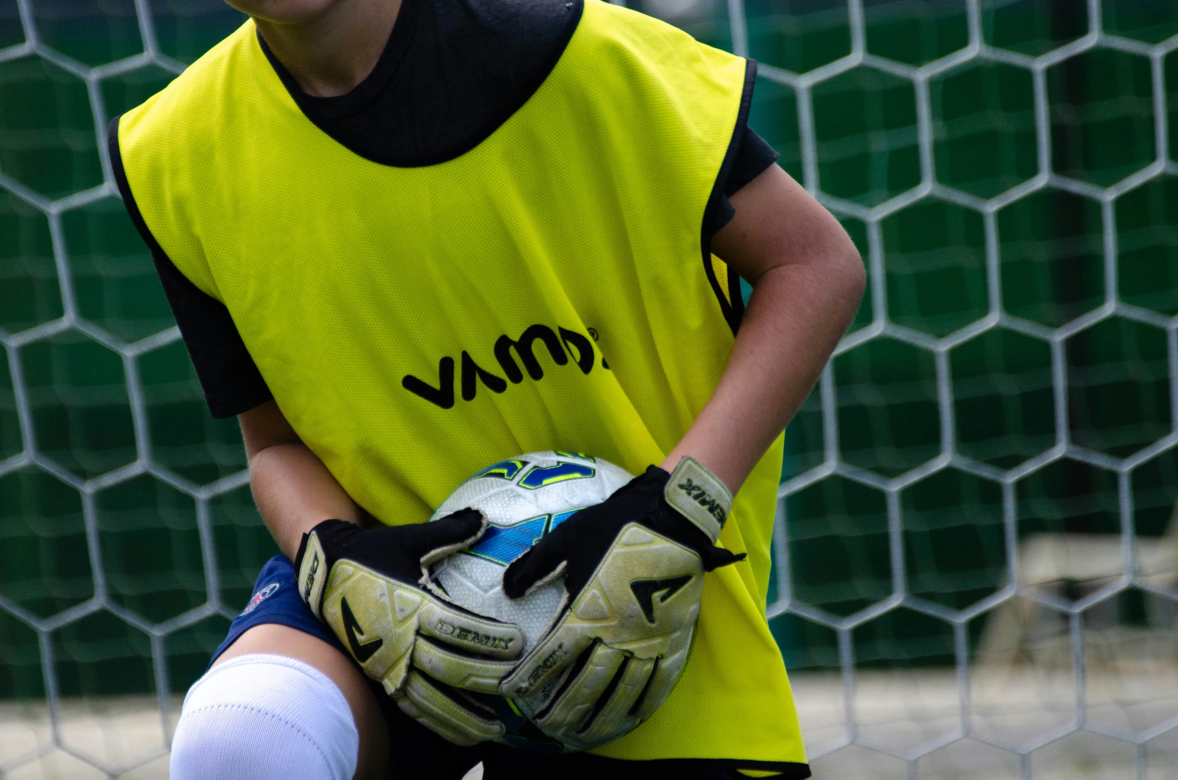 a  in a yellow jersey holding a soccer ball