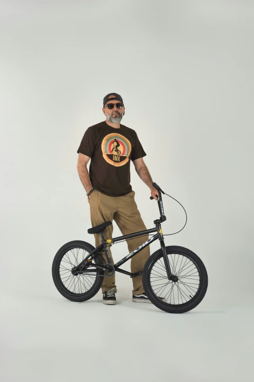 a man poses for a pograph with his bike