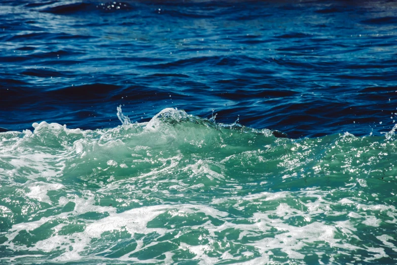 the ocean with blue sky above and waves coming in