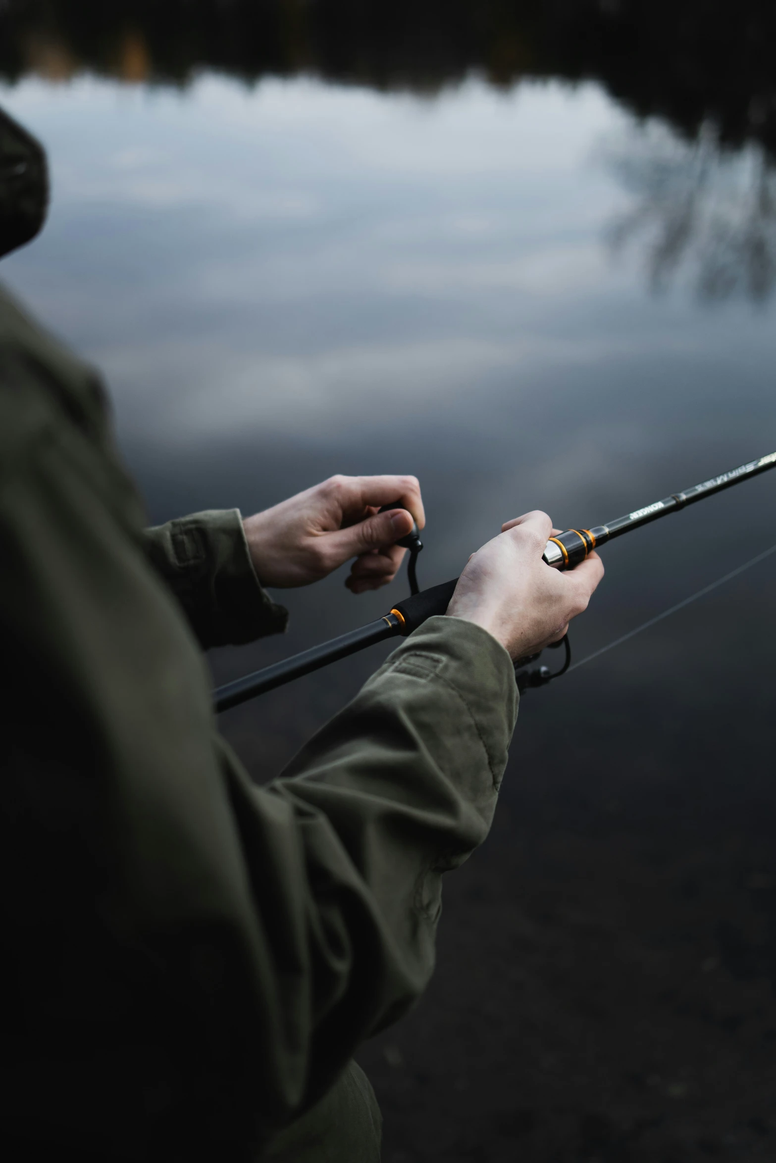 a man is fishing in a lake while holding his fishing pole