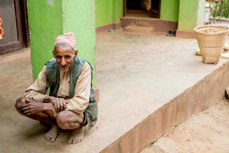 an old man is sitting on the cement outside