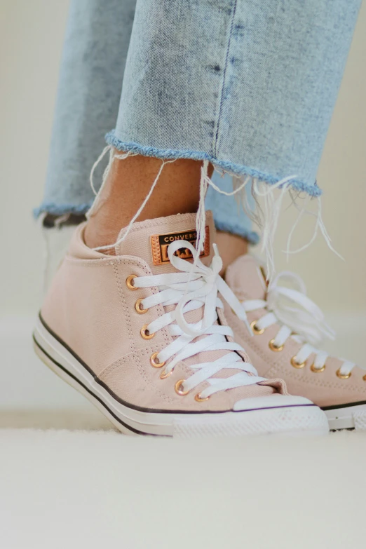 a woman with jeans and pink shoes standing