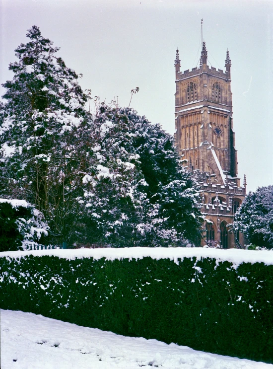a large tower with several clocks towering over a snowy hillside