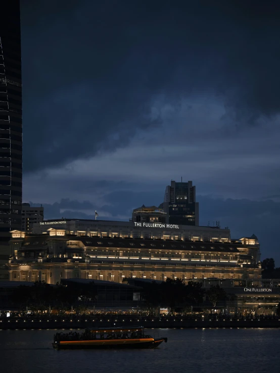 boats floating in the water near some tall buildings