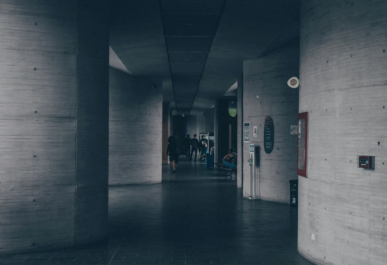 dark hallway with long columns and signs on each wall