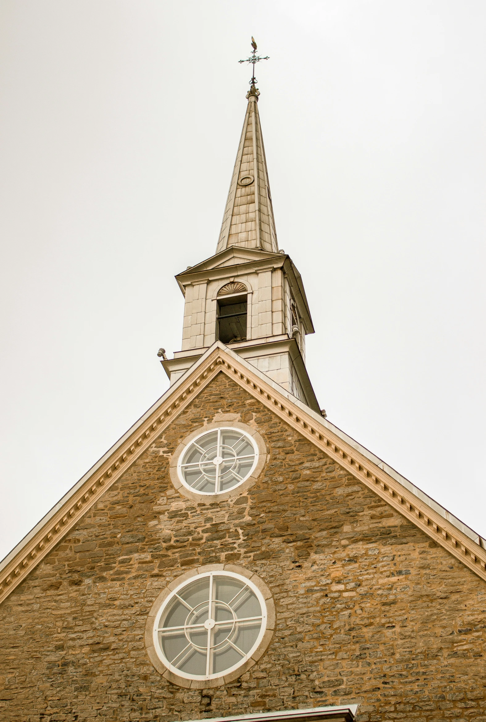 an old brick building with a steeple and two windows