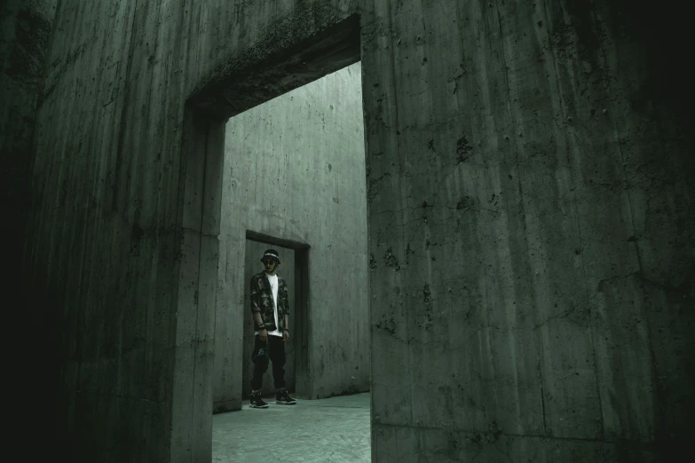 man standing on concrete floor next to doorway in dark tunnel