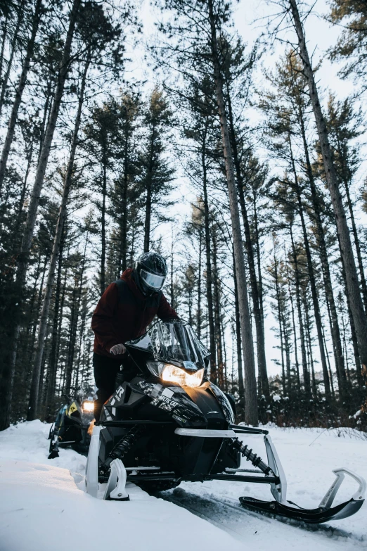 a man on a snowmobile with the snow in the forest