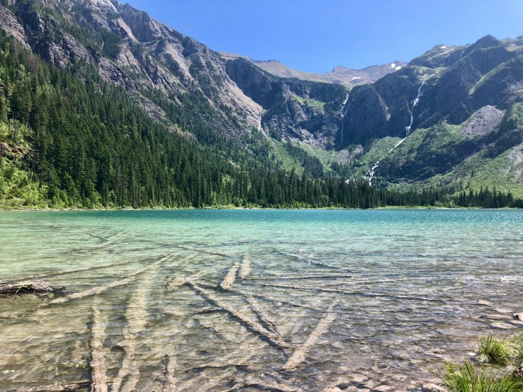 a clear, shallow lake with mountains in the background