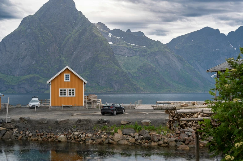 an orange cabin sits at the edge of the water