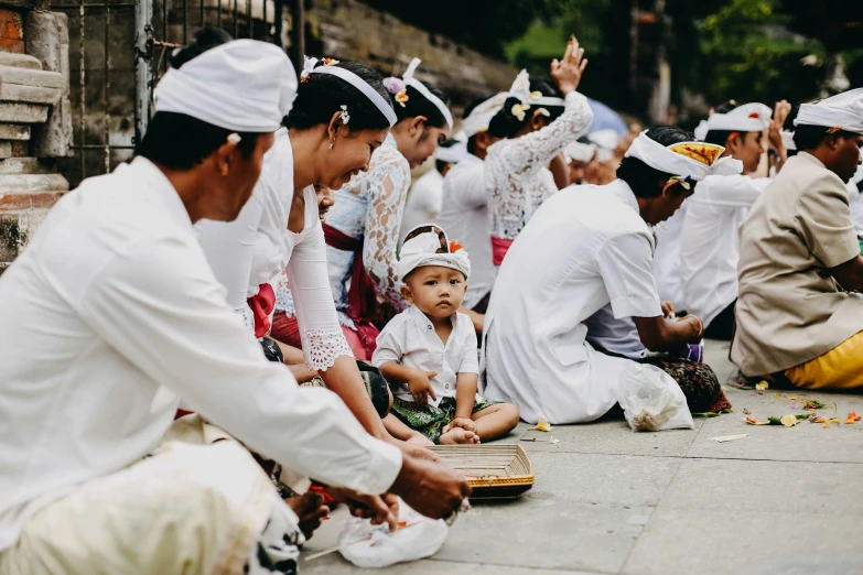 a group of people sitting on the ground next to each other