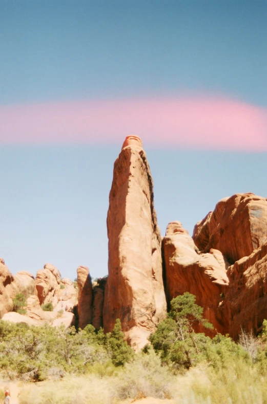 some very pretty rocks and bushes with some clouds